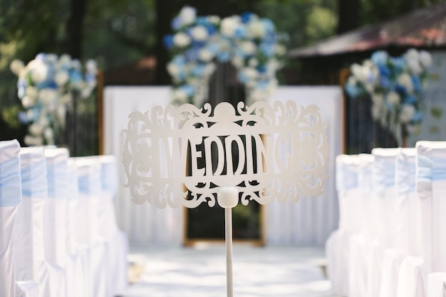 Foto cartello in legno bianco a forma di freccia e puntatore con iscrizione e lettere matrimonio