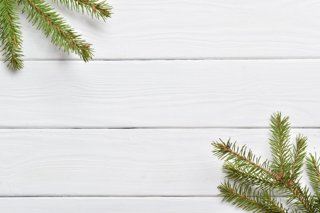 White wooden table and fir branches. Copy space. Flat lay, top view.