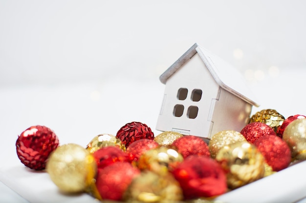 White wooden toy house with Christmas red and golden balls with white background