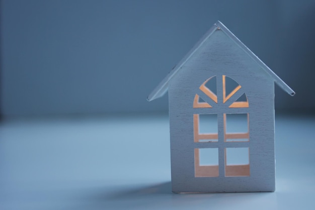 White wooden toy house with evening lighting with a glow inside