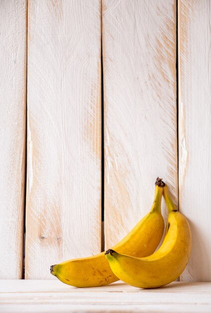 White wooden wall with two yellow bananas.