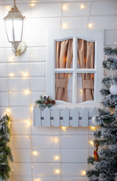 흰색 장식 창 크리스마스 장식과 가문비나무가 있는 흰색 나무 벽