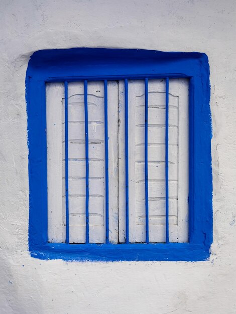 White wooden window with blue frame in the old medina of asilah