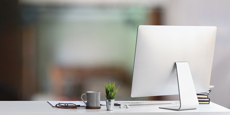 Photo a white working desk is surrounding by a computer monitor and office equipment