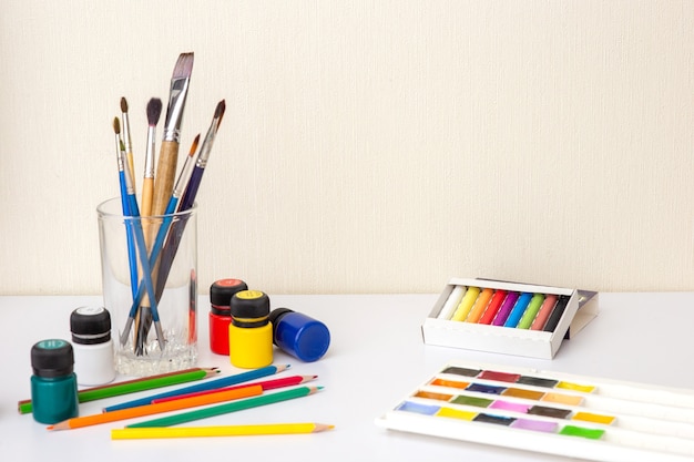 On a white worktop table with drawing supplies and brushes