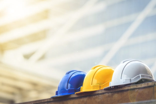 white, yellow and blue hard safety helmet hat for safety project of worker in big city.