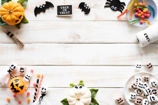 Photo white and yellow ghost pumpkins with bat spider mummy jelly worm on wooden background