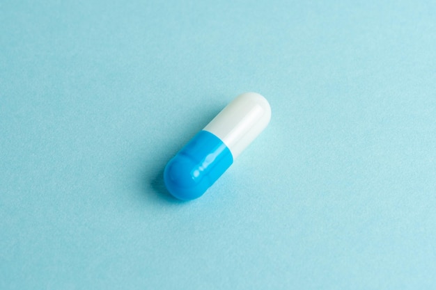 Whiteblue pill capsule on blue background