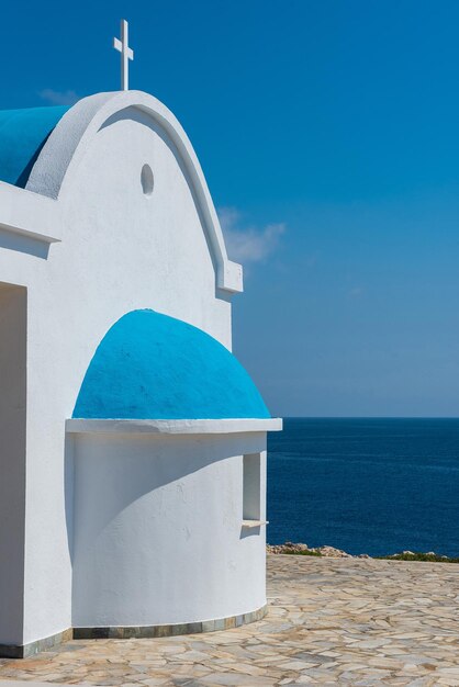 Whitewashed church with blue roof near the ocean