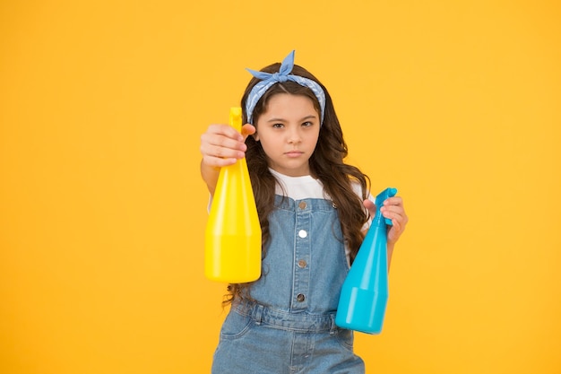 Who is on duty today Household as battle Girl cute kid cleaning around Protect sensitive skin Kid cleaning at home On guard of cleanliness Mist sprayer for wiping dust Girl ready for cleaning