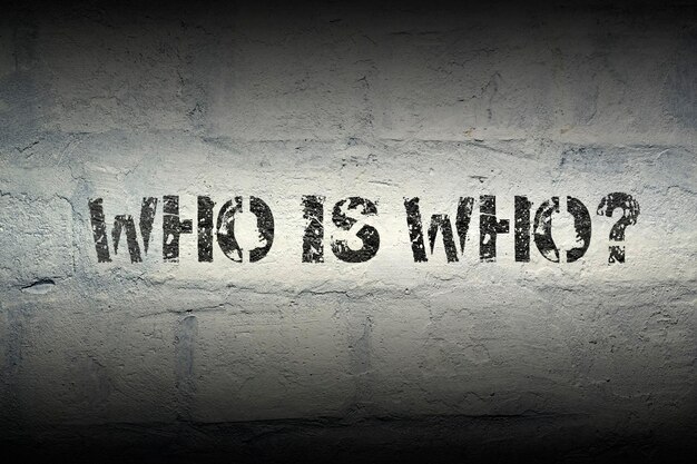 Who is who question stencil print on the grunge white brick wall