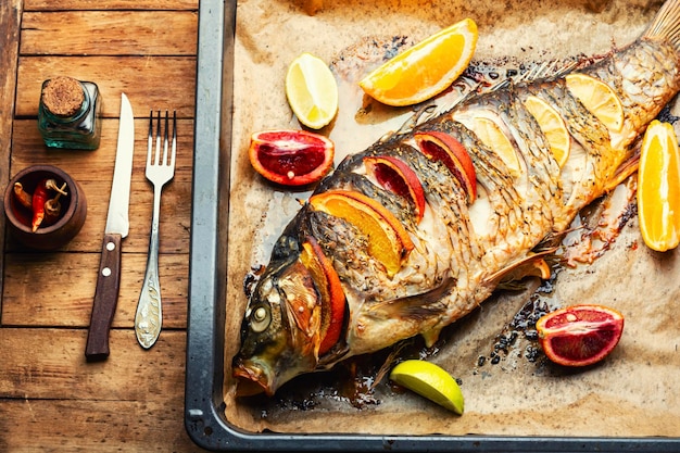 Whole baked carp with citrus fruits