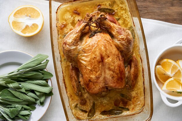 Whole baked chicken with sage in a glass form