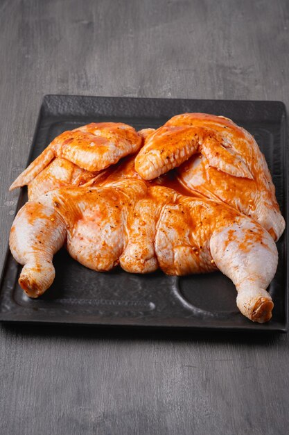 Foto carcassa di pollo intera con condimenti su sfondo grigio per il tuo menu di carne o il design del libretto