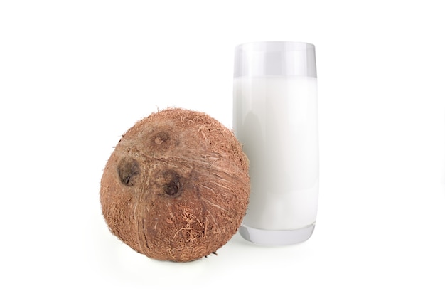 Whole coconut and coconut milk in a glass isolated on white cutout