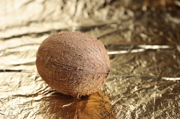 Whole coconut on golden surface