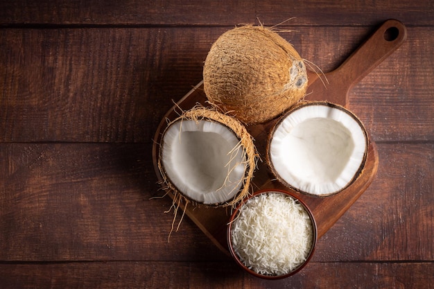 Whole coconut pieces of coconut and shredded coconut on the table