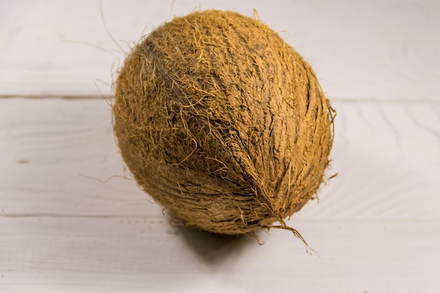 Whole coconut on white wooden table