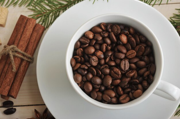 Целые кофейные зерна наливают в кофейную чашку