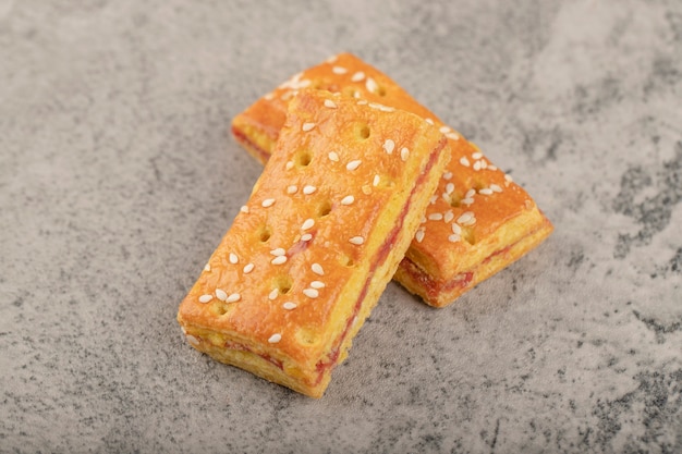 Whole crackers with sesame seeds placed on a stone table .