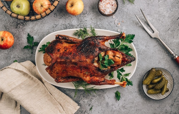 Photo whole crispy golden roast duck with marinated with fresh apples for a festive dinner on concrete background top view