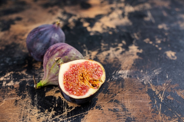 Whole and cut fresh figs on wooden table