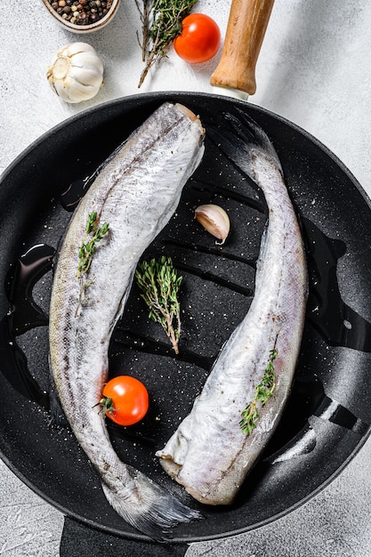 Whole fish Pollock in a pan. Raw seafood. Top view