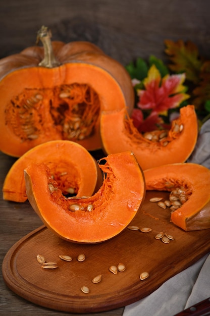 Whole fresh pumpkin and slice of pumpkin on wooden board Organic vegetable product ingredients