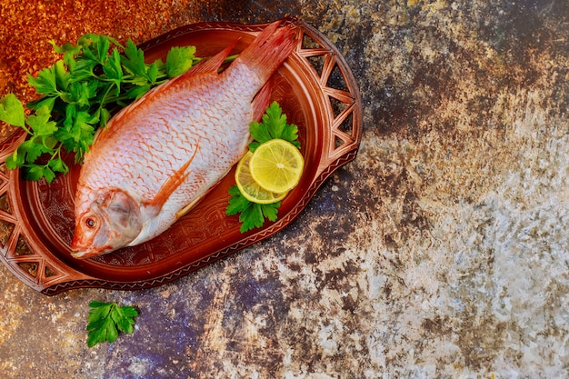 Whole fresh tilapia with spices and lemon. Top view. Copy space.