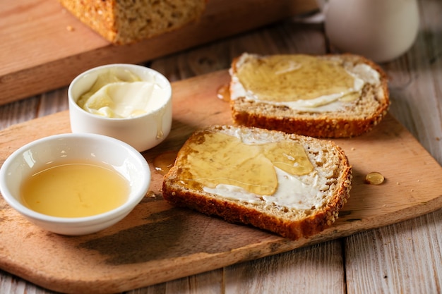 Whole grain bread slices with butter and honey