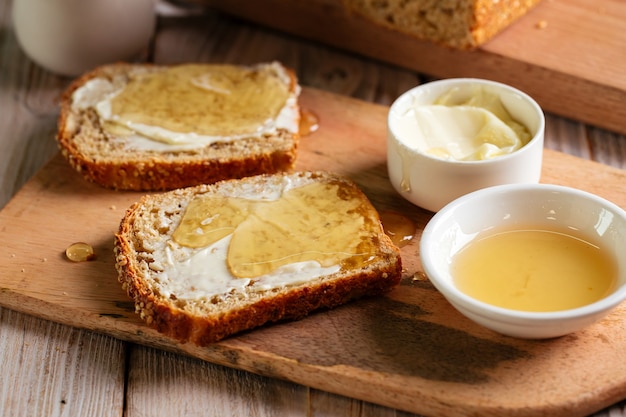 Whole grain bread slices with butter and honey