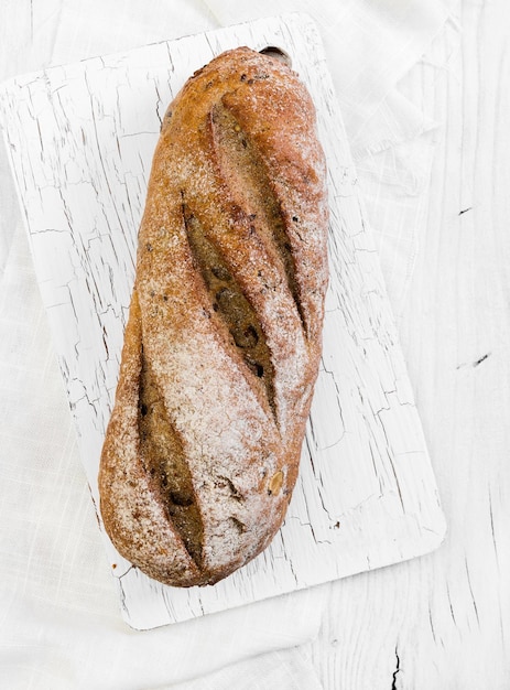 Whole grain bread on white wooden background