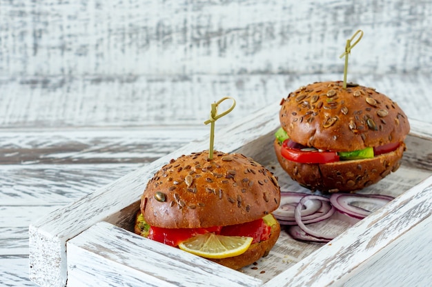 Whole-grain bun stuffed with salad, salmon, avocado and tomatoes. Healthy food concept.