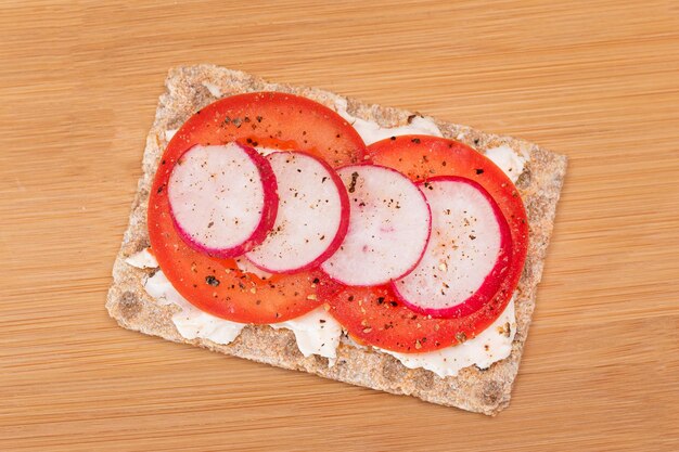 Whole grain crispbread with tomato cream cheese and radish