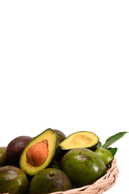 Whole and a half of avocado in basket isolated on white background