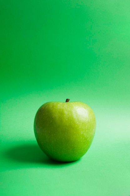 Tutta la mela verde di granny smith isolata su sfondo verde