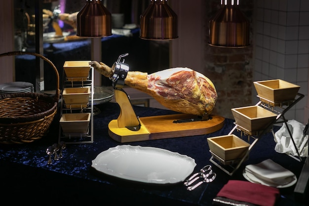 Whole jamon on a wooden stand in the restaurant banquet welcome table