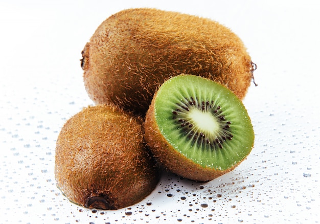 Whole kiwi fruit and his sliced segments isolated