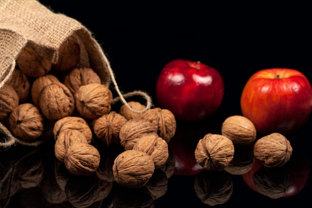 Whole nuts and apples on a table on a black background