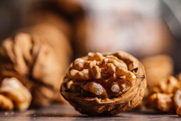 Целые и открытые грецкие орехи с зерном грецкого ореха на деревянном столе