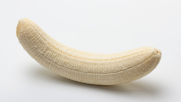 Whole peeled banana on a white background