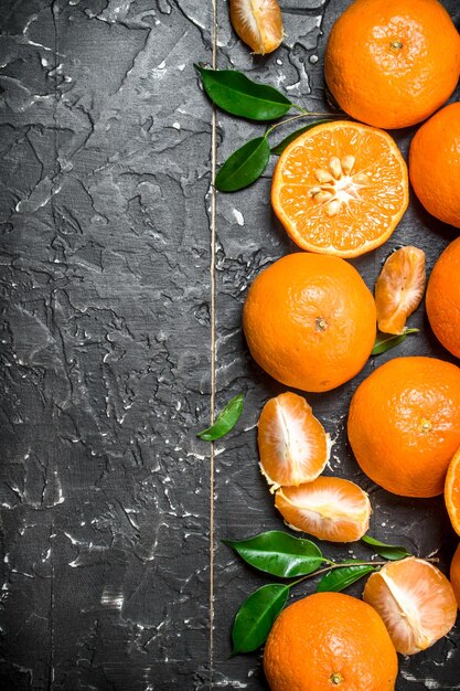 Photo whole and pieces of mandarins with leaves