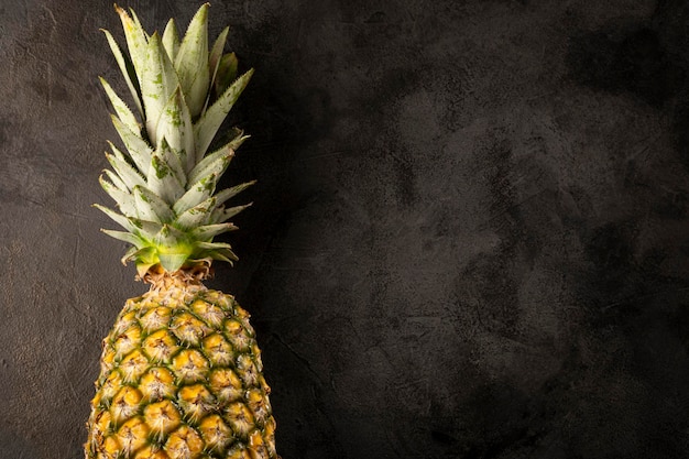 Whole pineapple on dark background.