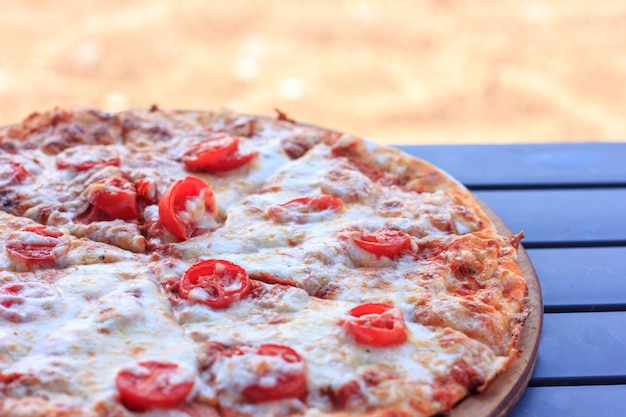 Whole pizza Margarita with tomatoes and cheese.