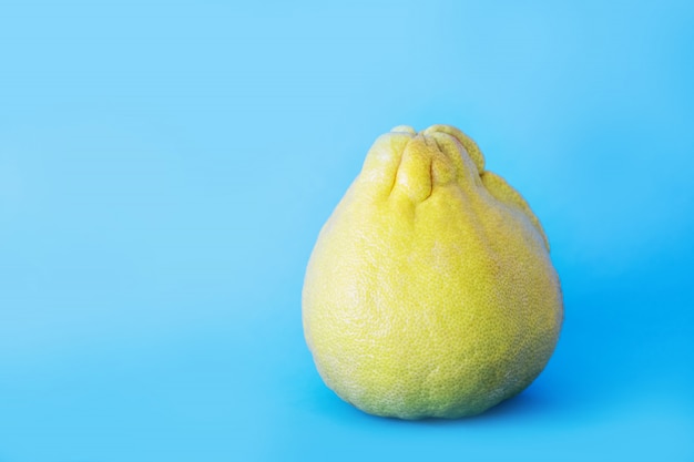 Pomelo intero su uno sfondo blu