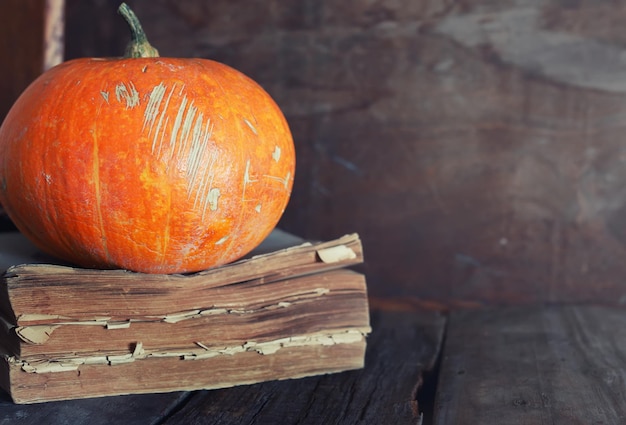 Whole pumpkin on old wooden book