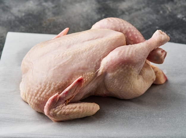 Whole raw chicken on white paper Preparing raw chicken