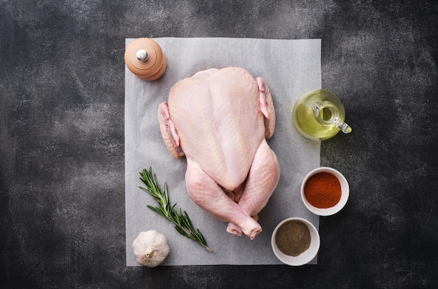 Whole raw chicken on white paper preparing raw chicken