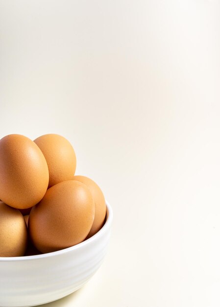 Whole raw egg in white bowl Close up Vertical Broken White Background Place for text