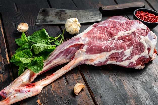 Photo whole raw goat leg with herbs and spices